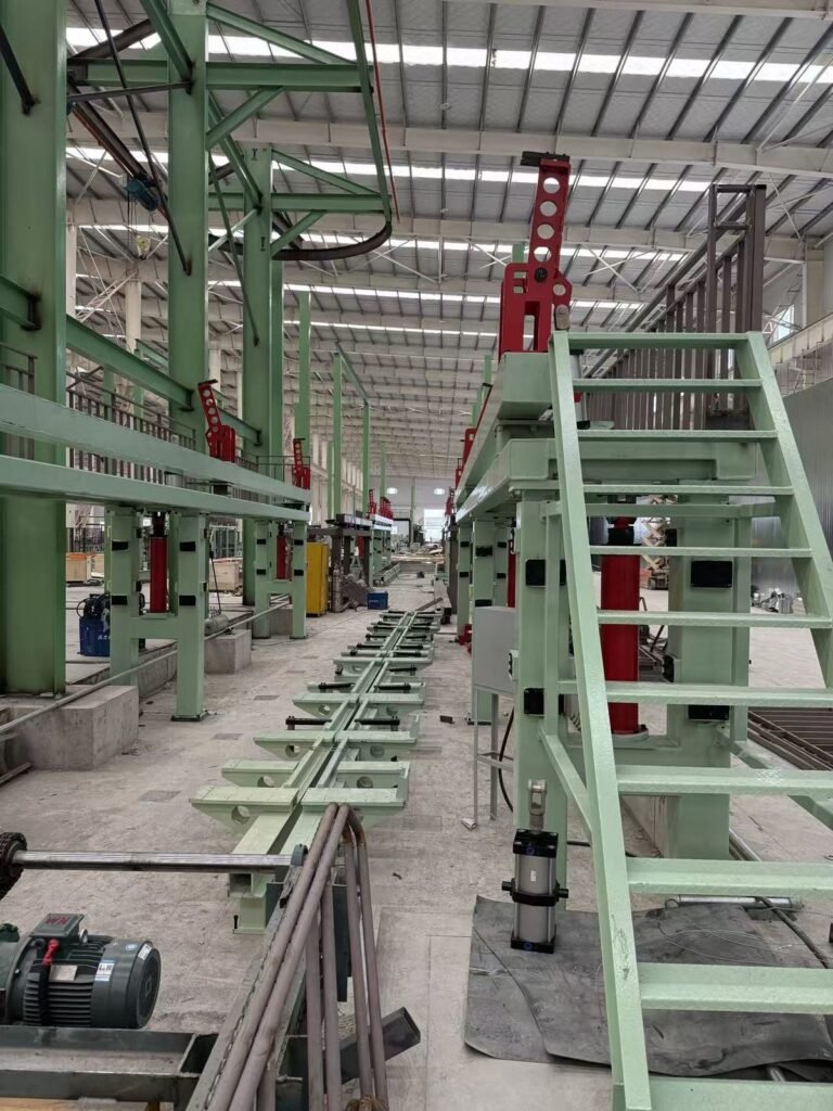Estações de elevação hidráulica e braços de fixação ao longo de uma linha de pintura de contêineres marítimos