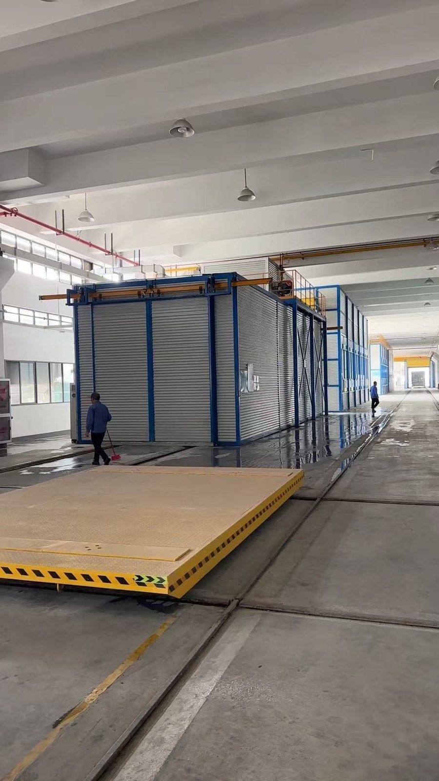 Rail transfer cart in front of a container spray booth