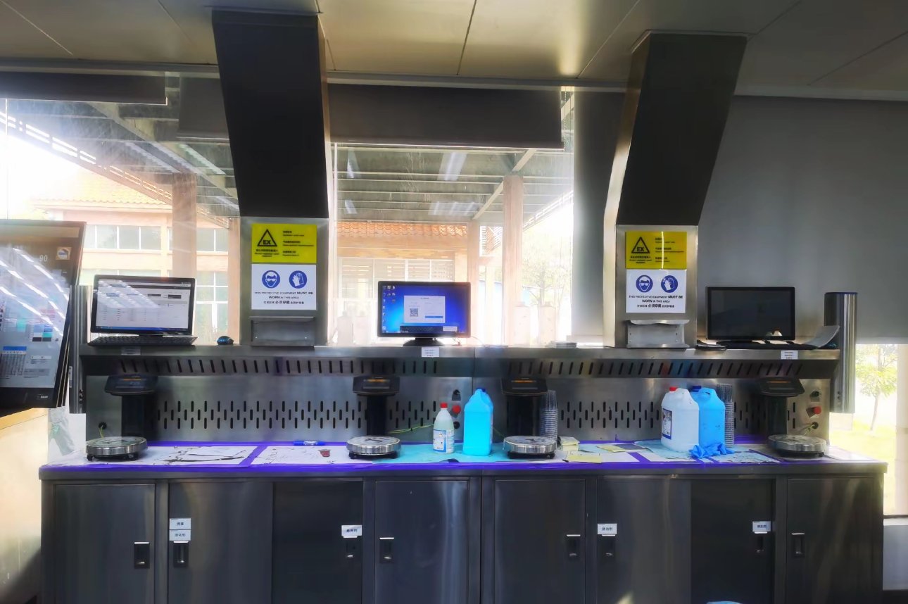 Paint mixing bench with extraction hoods, explosion-proof warning signs, electronic scales and mixing software terminals
