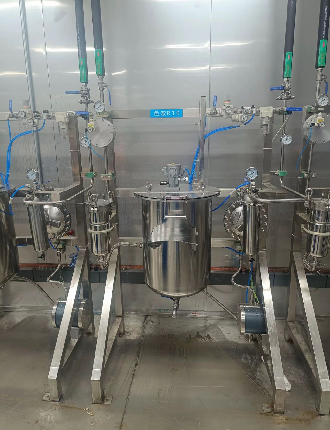 Stainless steel paint pressure tank with pneumatic agitator, in-line filters and gauges at colour station R10 in a paint mixing room