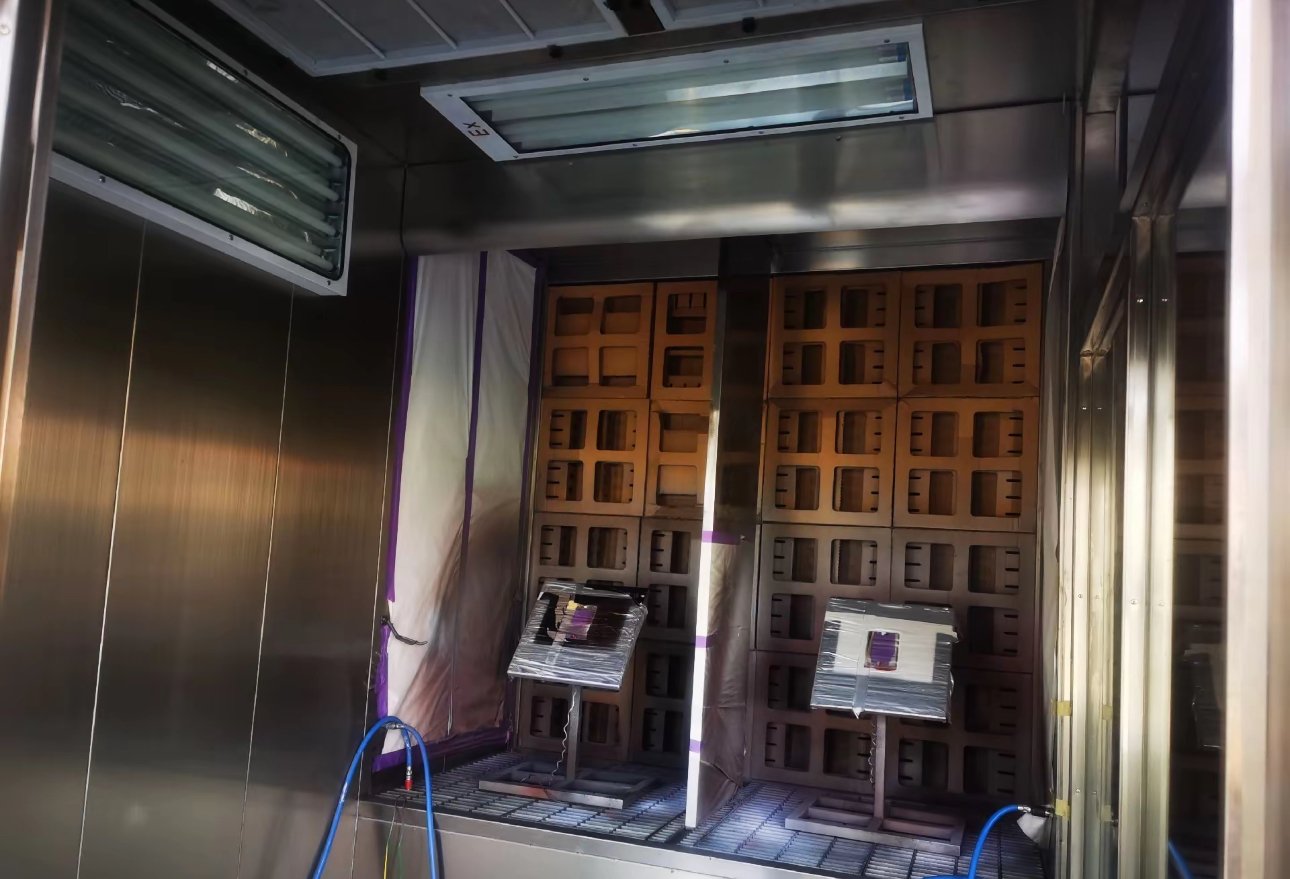 Small paint test spray booth with explosion-proof lighting, dry filter wall and sample panels on stands