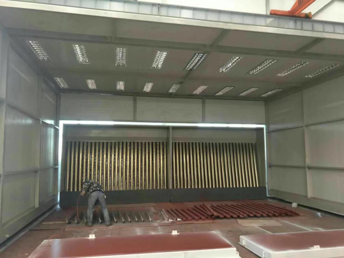 Interior of a large telescopic spray booth with corrugated dry filter wall and rows of ceiling lights