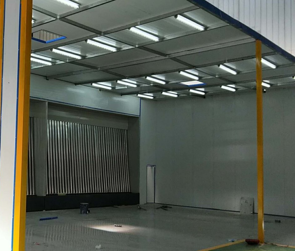 Innenraum einer Teleskop-Spritzkabine mit Trockenlacknebel-Filterwand, Deckenbeleuchtung und gelben schienenmontierten Säulen