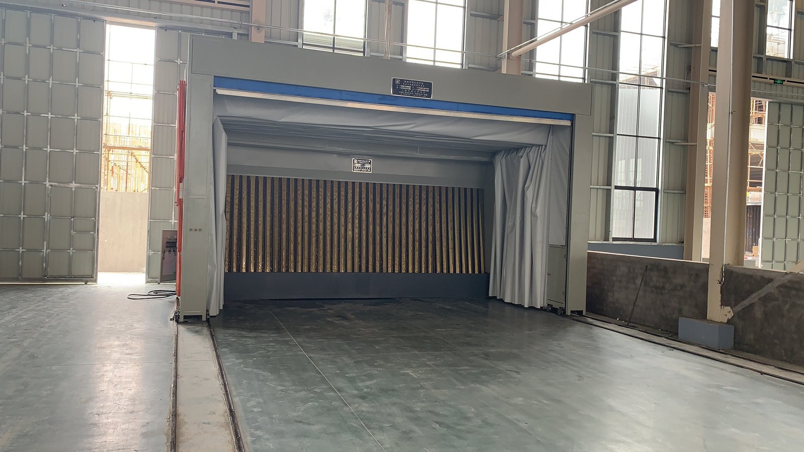 Telescopic spray booth interior with filter wall, folded fabric side walls and floor rails